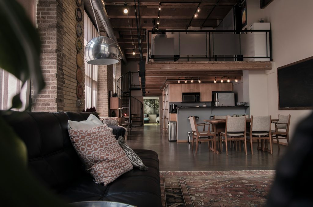 A light-filled industrial loft where charcoal accents and warm wood tones create a balanced dialogue between raw structure and refined comfort.